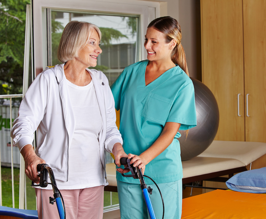 Physiotherapeutin hilft Patientin beim Gehen