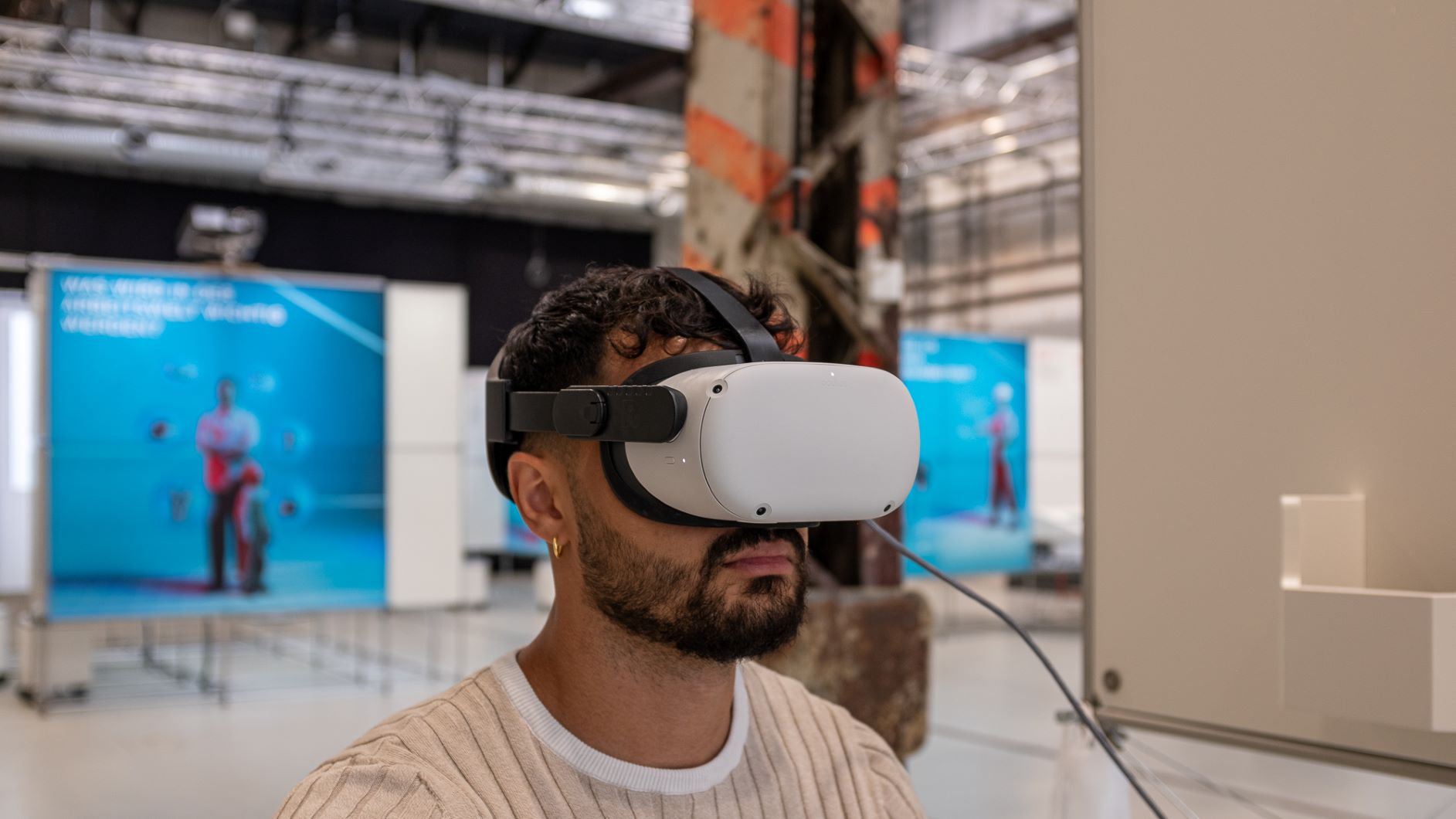 Mann mit VR Brille in der Wanderausstellung "Arbeit im Wandel"