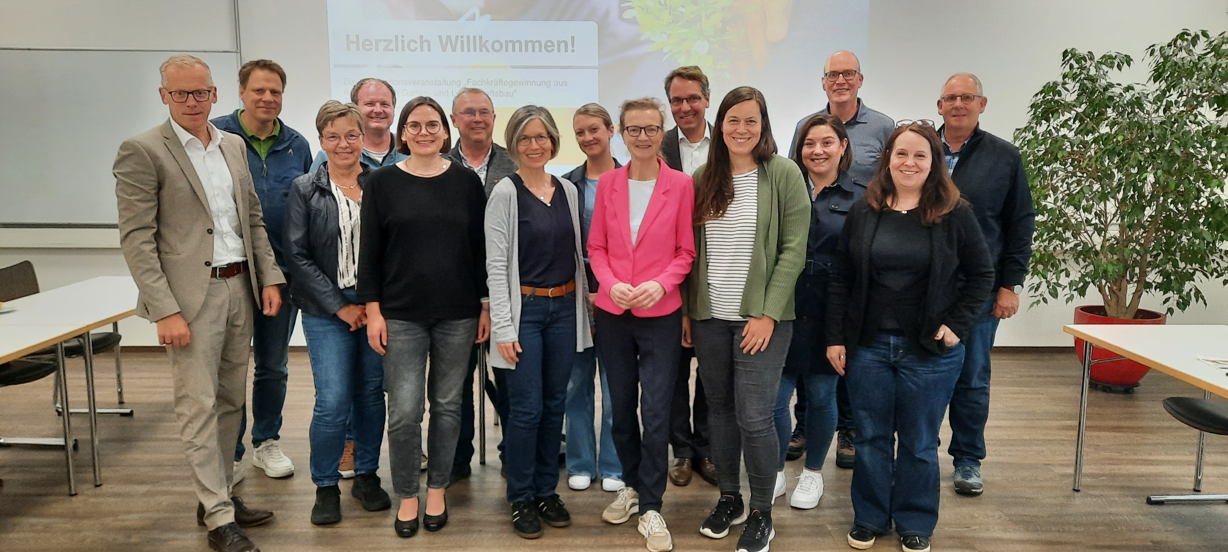 Eine Gruppe Menschen steht zusammen und schaut freundlich in die Kamera