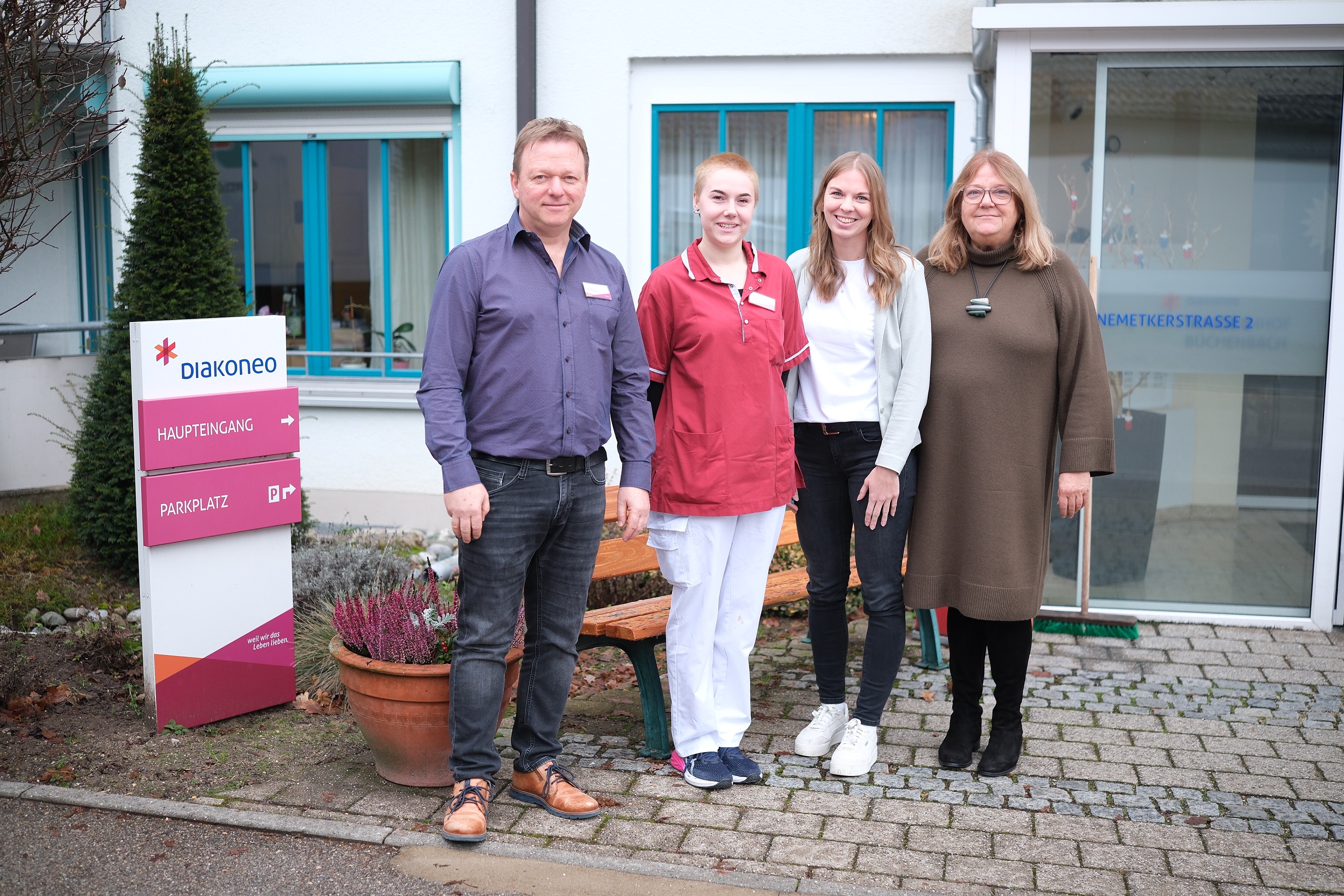 Bild mit Meschen vor einer Pflegeeinrichtung