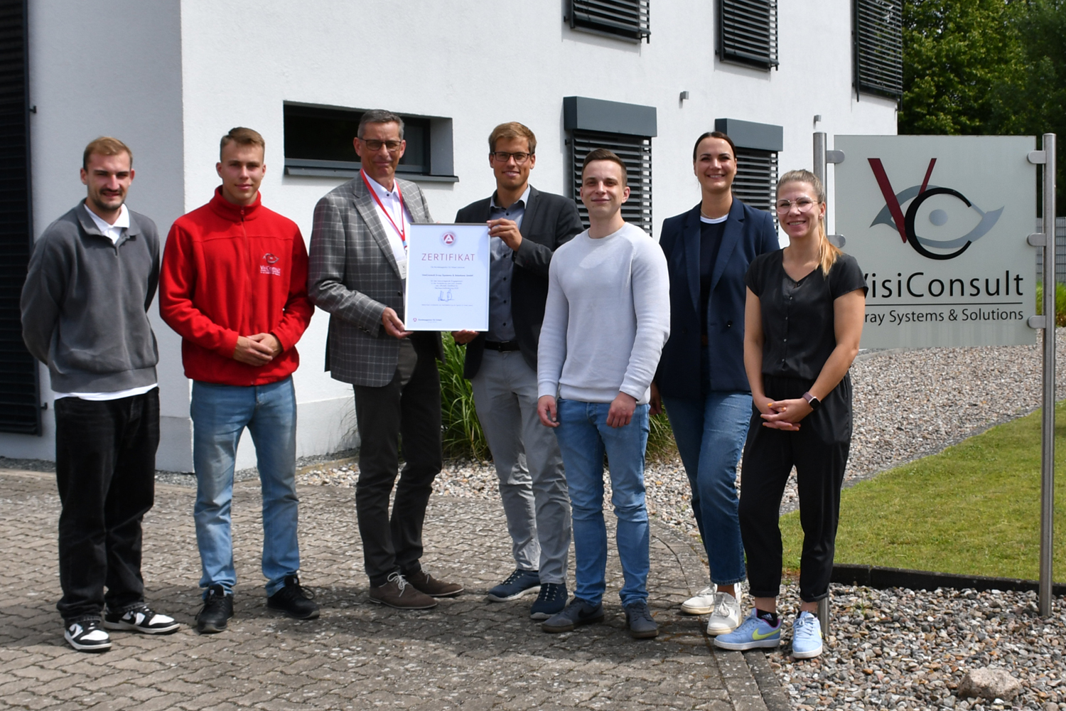 Mitarbeitern der Firma wird ein Zertifikat vom Geschäftsführer der Agentur für Arbeit Lübeck überreicht