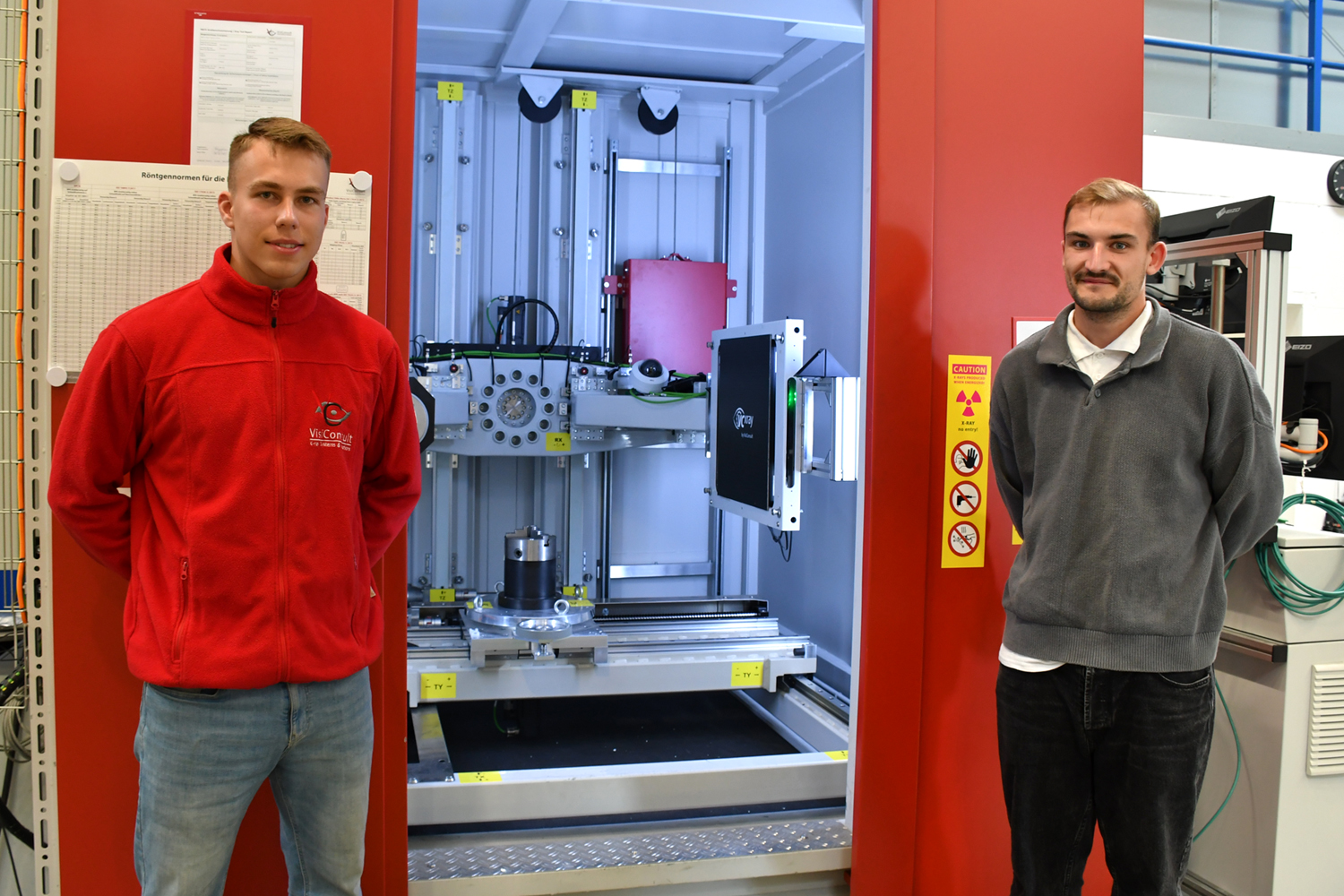 Zwei Mitarbeiter zeigen eine Röntgeninspektionsanlage