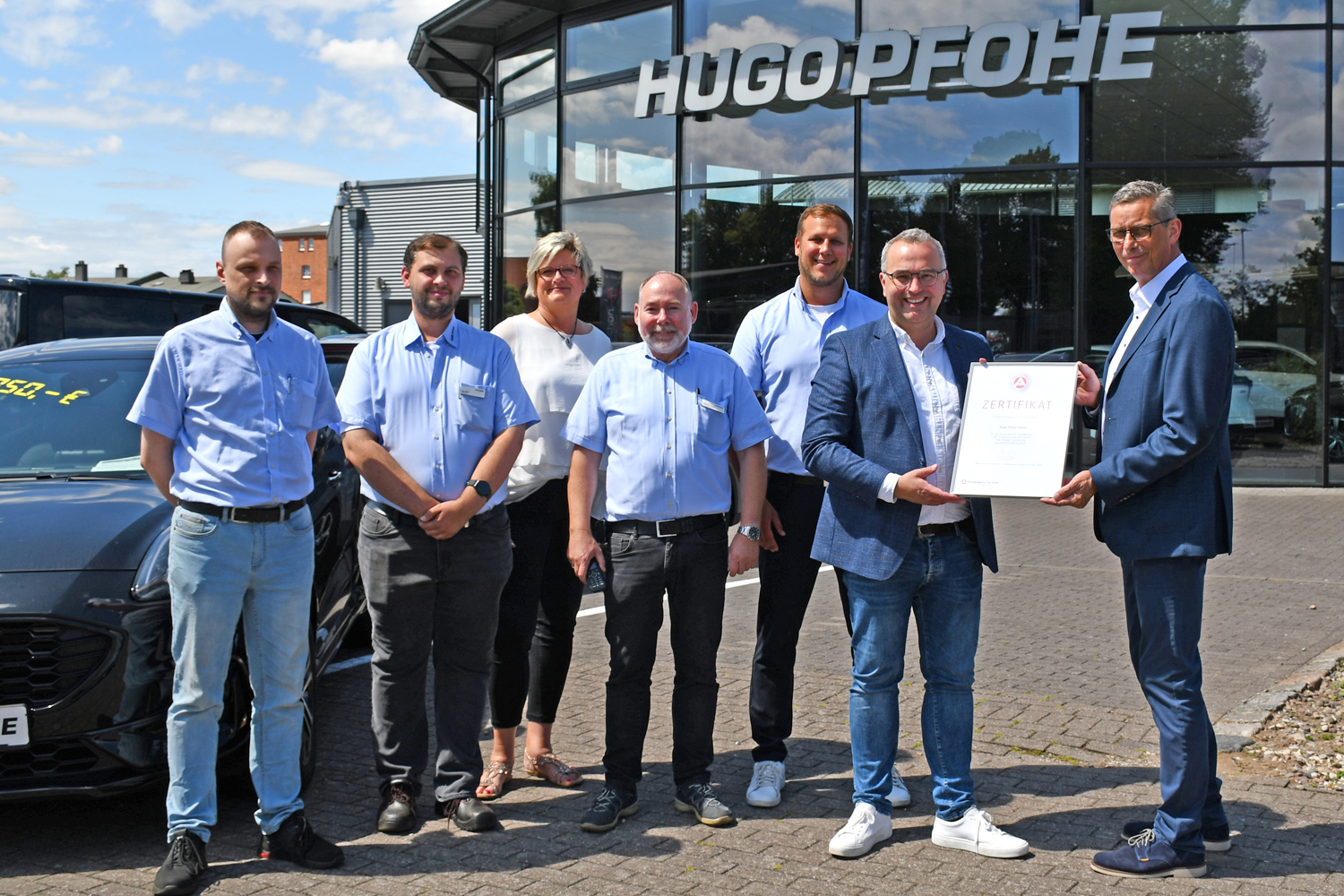 Mitarbeitern der Firma wird ein Zertifikat vom Geschäftsführer der Agentur für Arbeit Lübeck überreicht