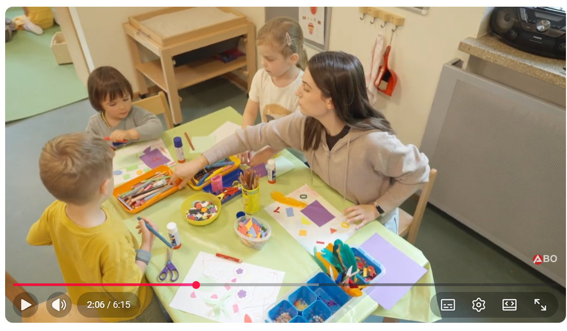 Erzieherin malt mit Kindergarten-Kindern am Tisch