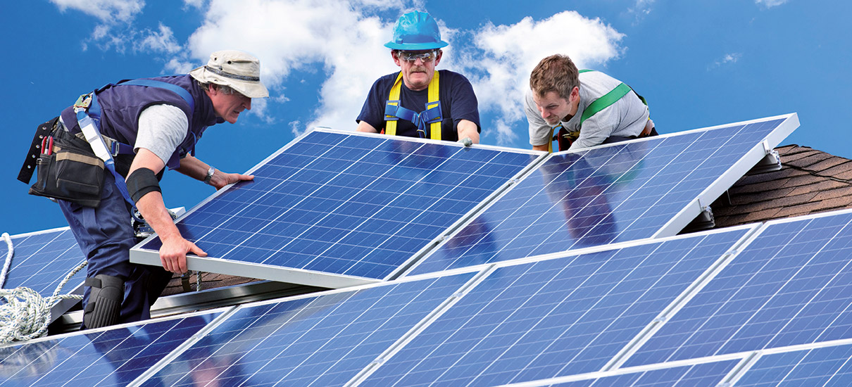 Techniker installieren Solarzellen auf einem Dach
