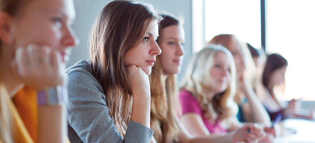 Junge Frauen folgen einem Vortrag in einer Schule oder Hochschule
