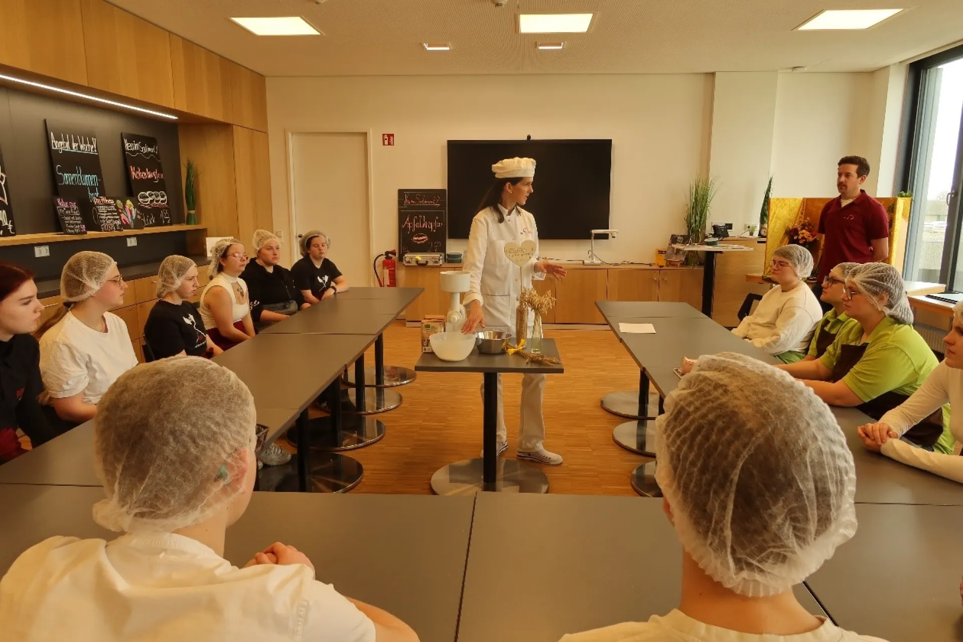 Bevor es ans Backen geht, erklärt Melanie Zoll-Albert den Schülern, wie Mehl hergestellt wird und welche unterschiedlichen Körner es gibt. 