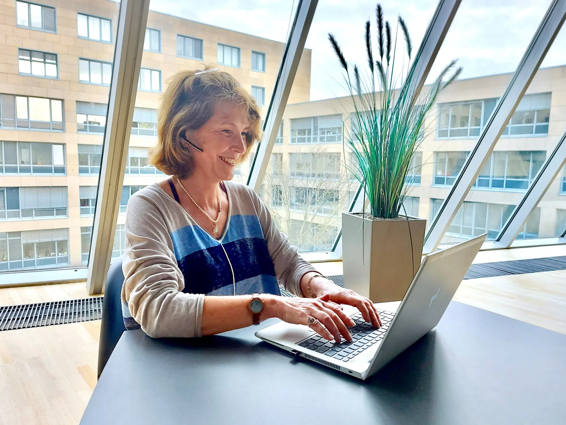 Frau Dr. Helen Fulda vor einem aufgeklappten Laptop am Tippen.