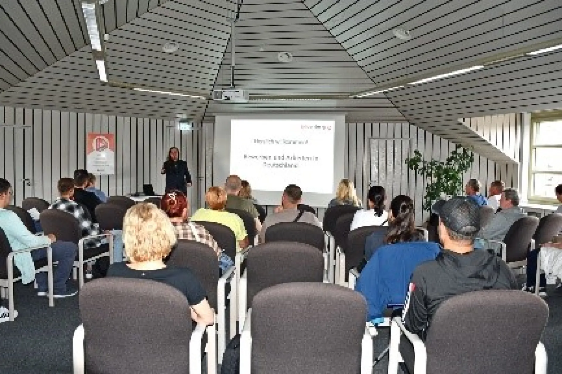 In einem Sitzungssaal wird eine Präsentation gehalten