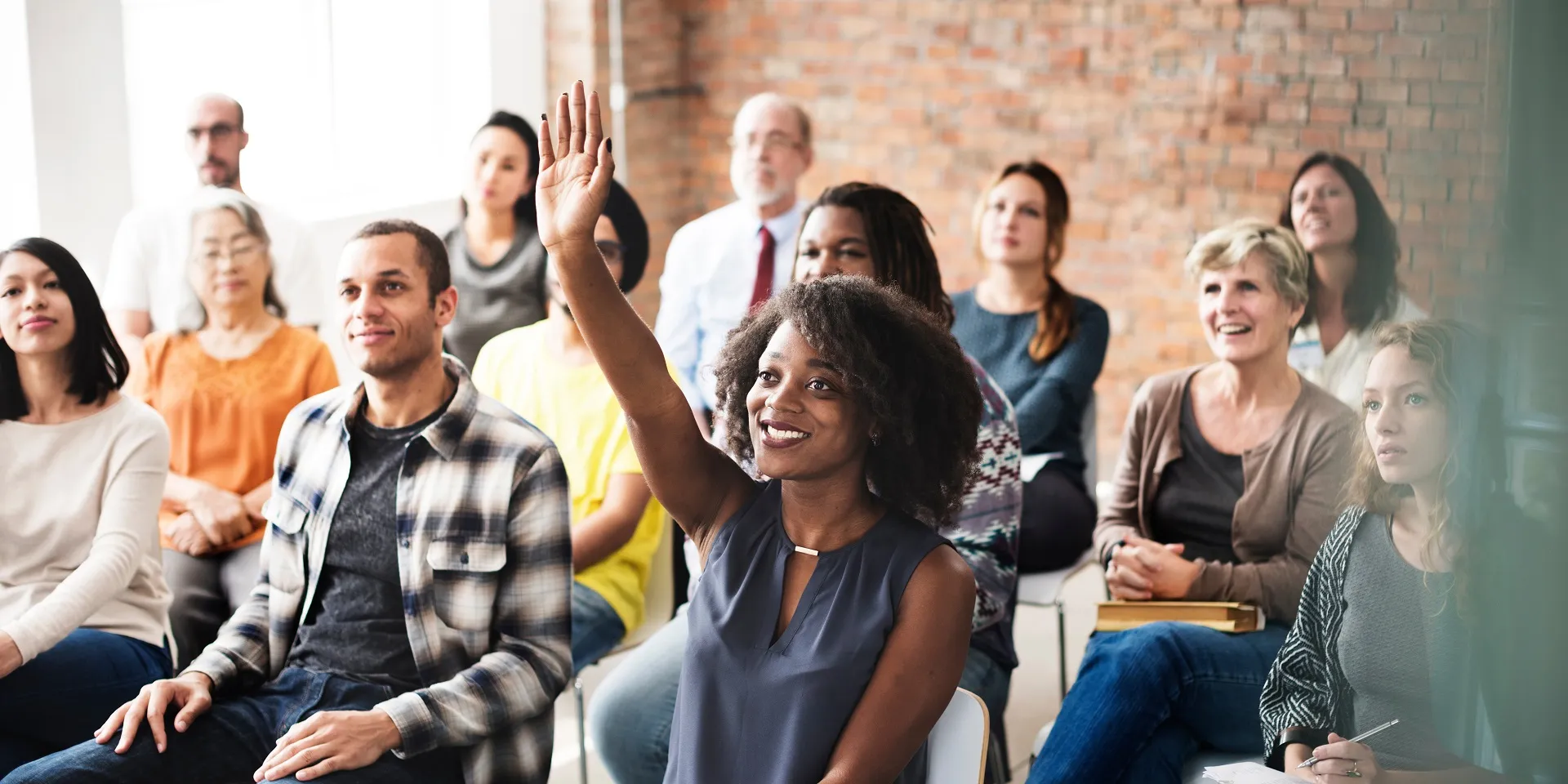 Eine Personengruppe beteiligt sich an einem Seminar.