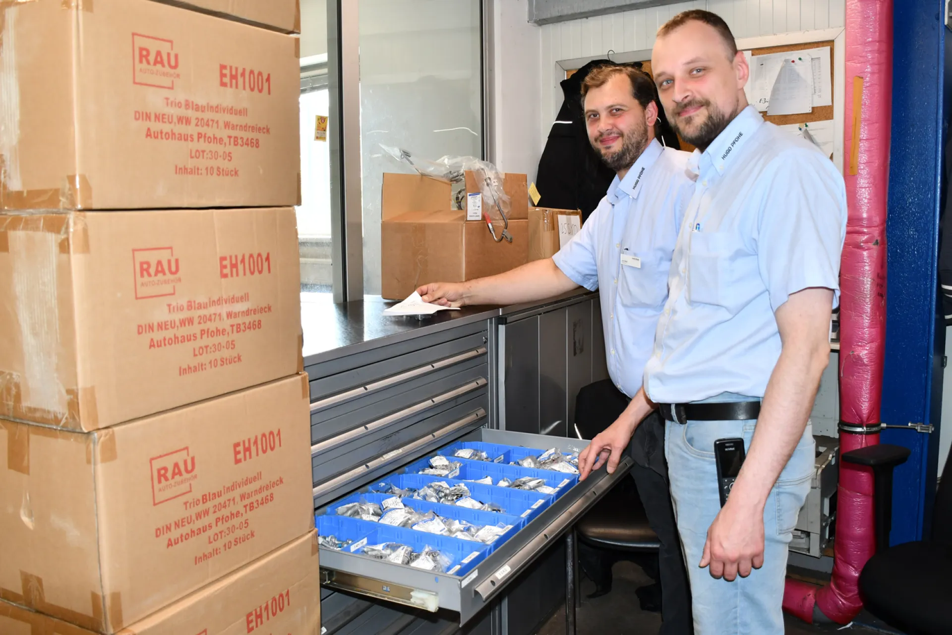 Zwei Mitarbeiter zeigen das Lager der Firma