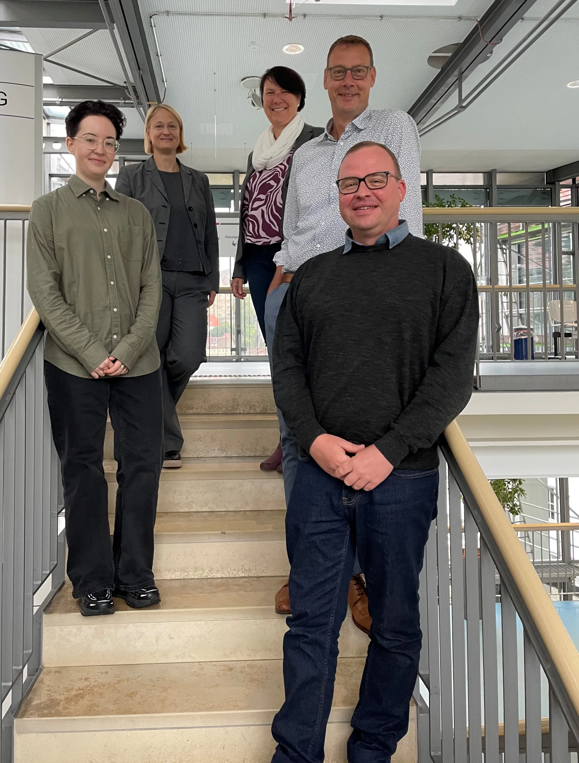 Auf diesem Bild stehen Frau Fröhlich, Frau Giesen, Frau Vogt, Herr Greff und Herr Kientzl (von links nach rechts) auf der Treppe