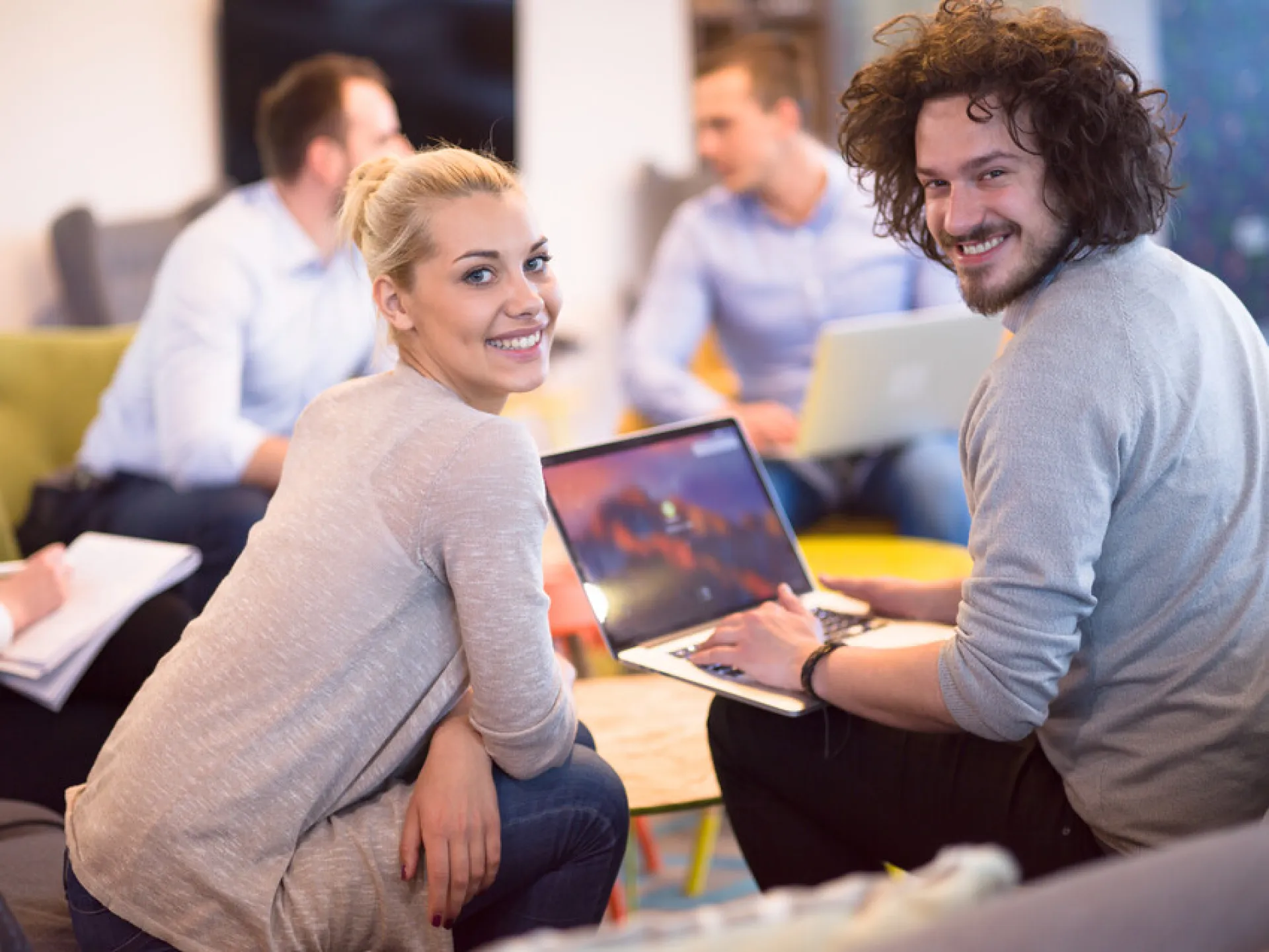 Team arbeitet mit Laptop in Büro