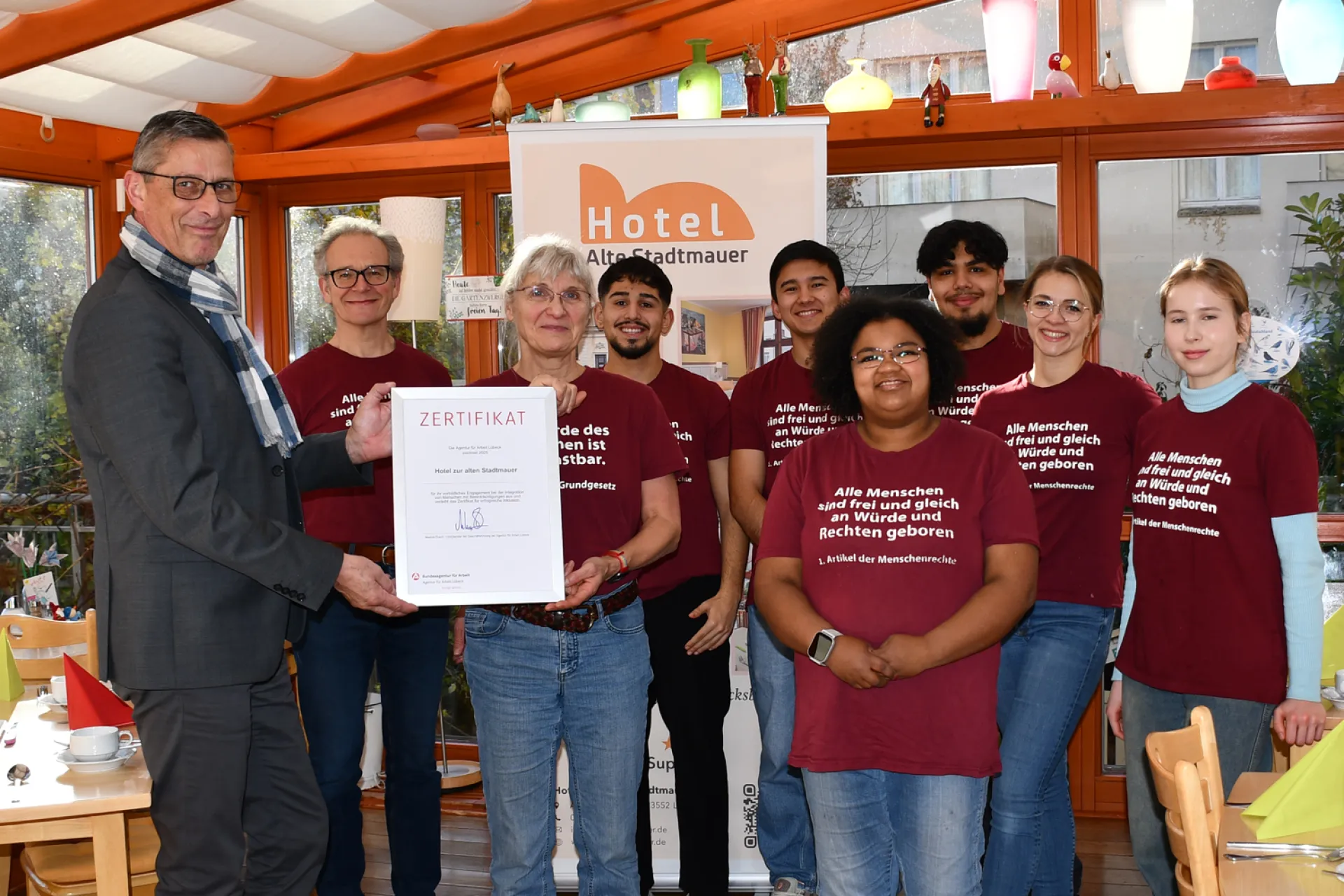 Markus Dusch, Vorsitzender der Geschäftsführung der Agentur für Arbeit Lübeck übergibt das Inklusionszertifikat