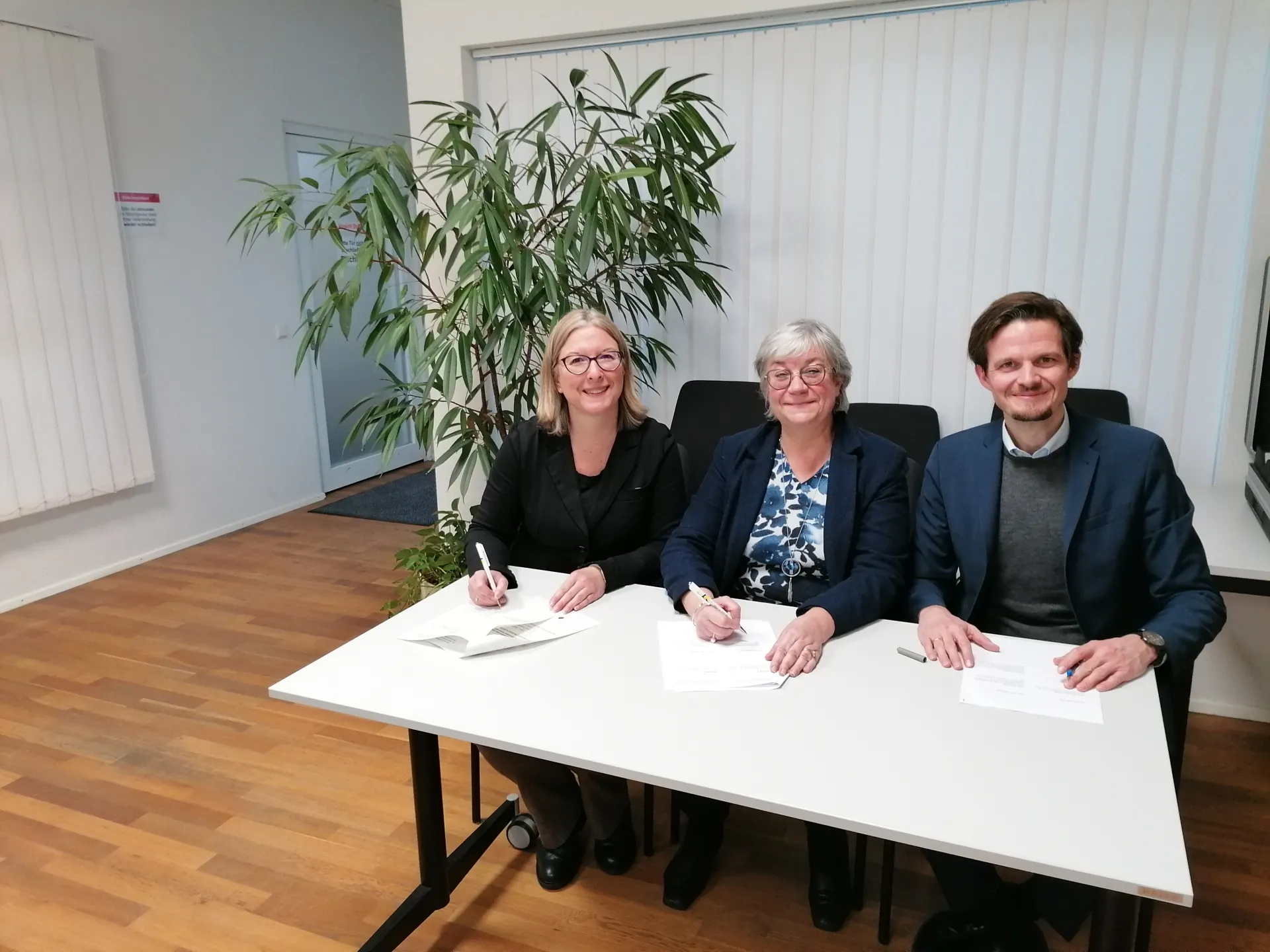 2 Frauen und 1 Mann unterzeichnen das Partnerschaftsabkommen