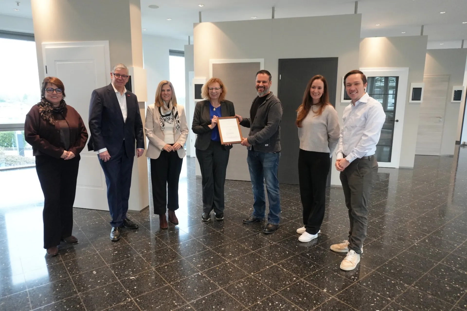 7 Personen stehen im Halbkreis