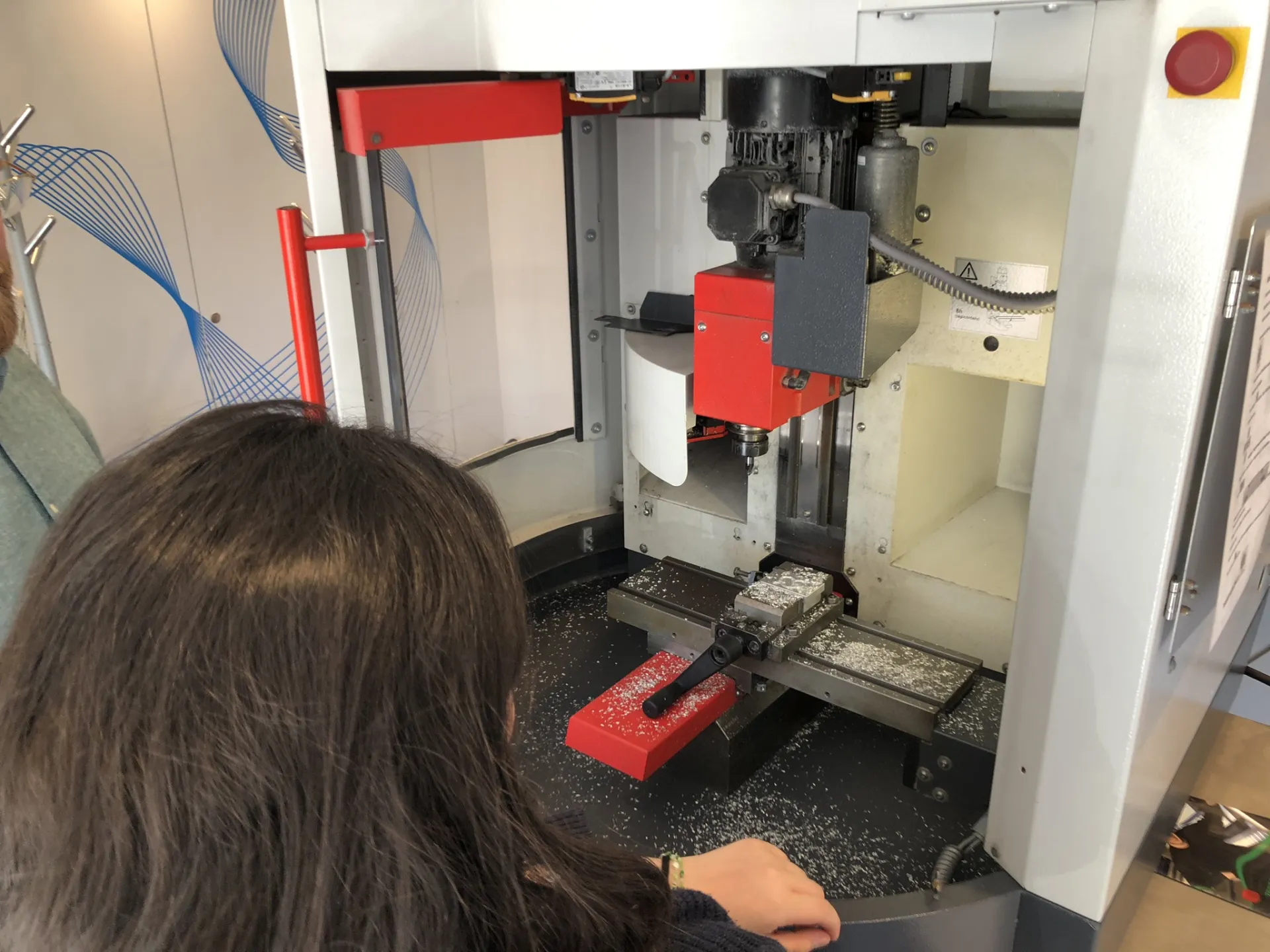 Mädchen sitzt vor einem Metallbohrer