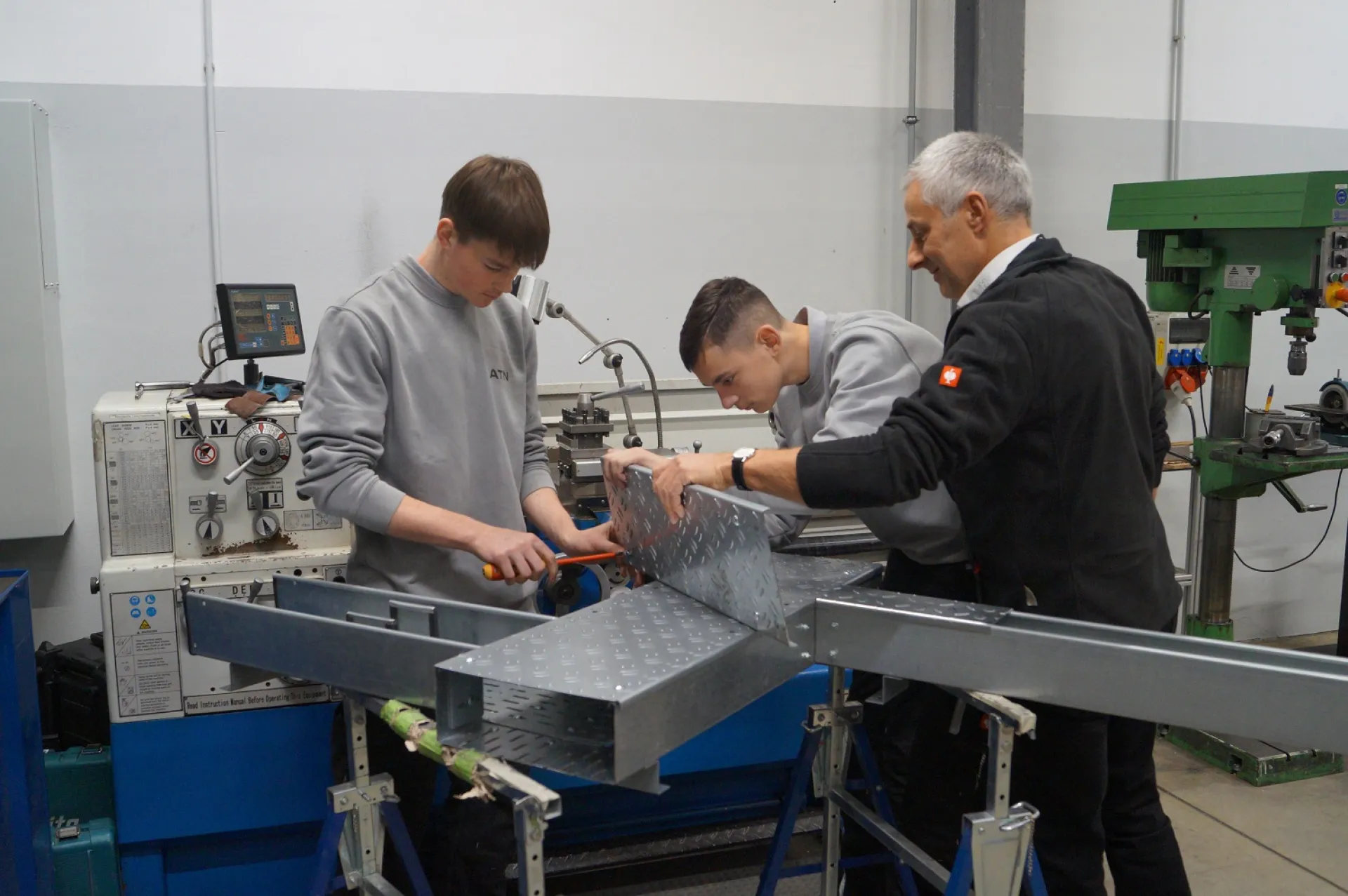 Einblick in die hauseigene Lehrwerkstatt der ATN Hölzel GmbH: Zwei Auszubildende üben mit Steffen Reck, Leiter Lehrausbildung ge