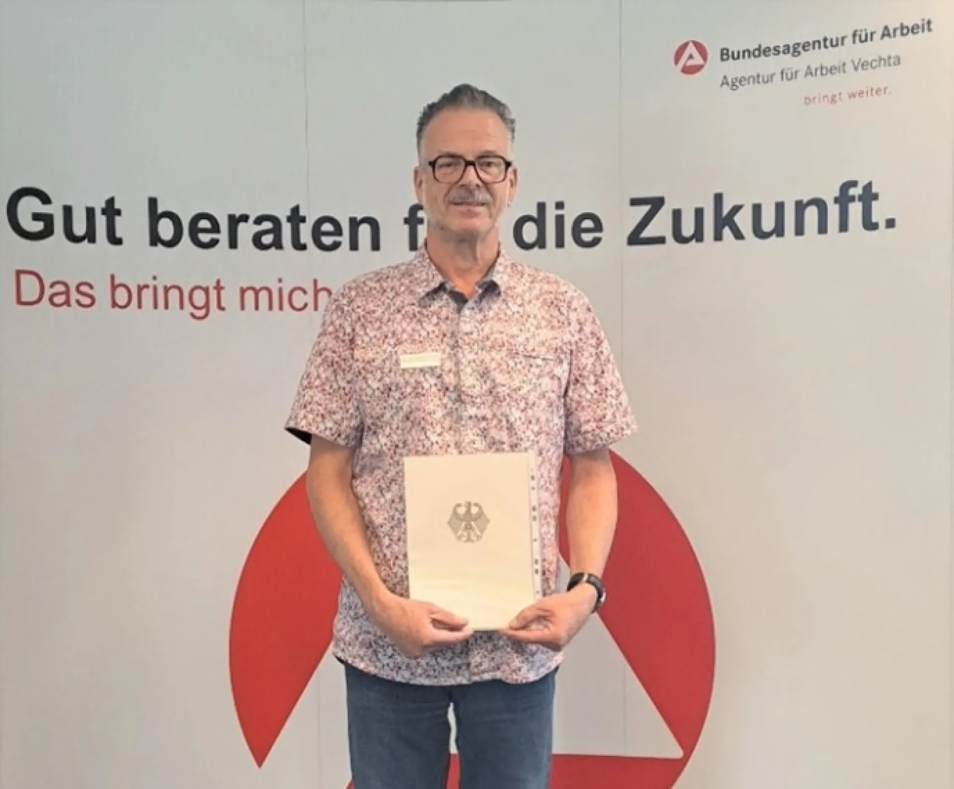 Uwe Möller, Mitarbeiter im BiZ der Agentur für Arbeit Vechta, präsentiert seine Urkunde für langjährige engagagierte Mitarbeit.