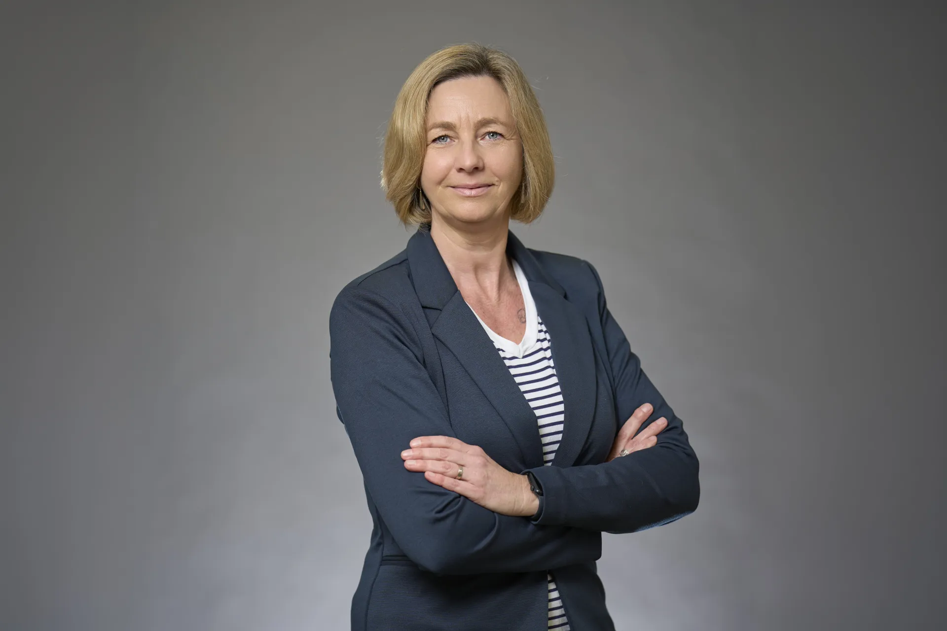 Junge Frau mit weißem Pullover und rotem Namensschild M. Thiel