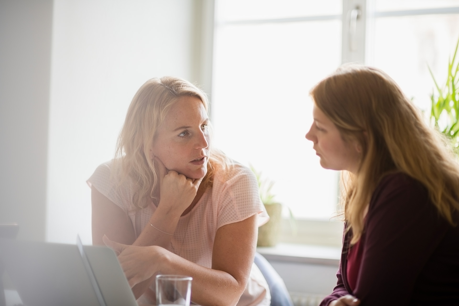 Zwei Frauen am Arbeitsplatz im vertrauensvollen Gespräch