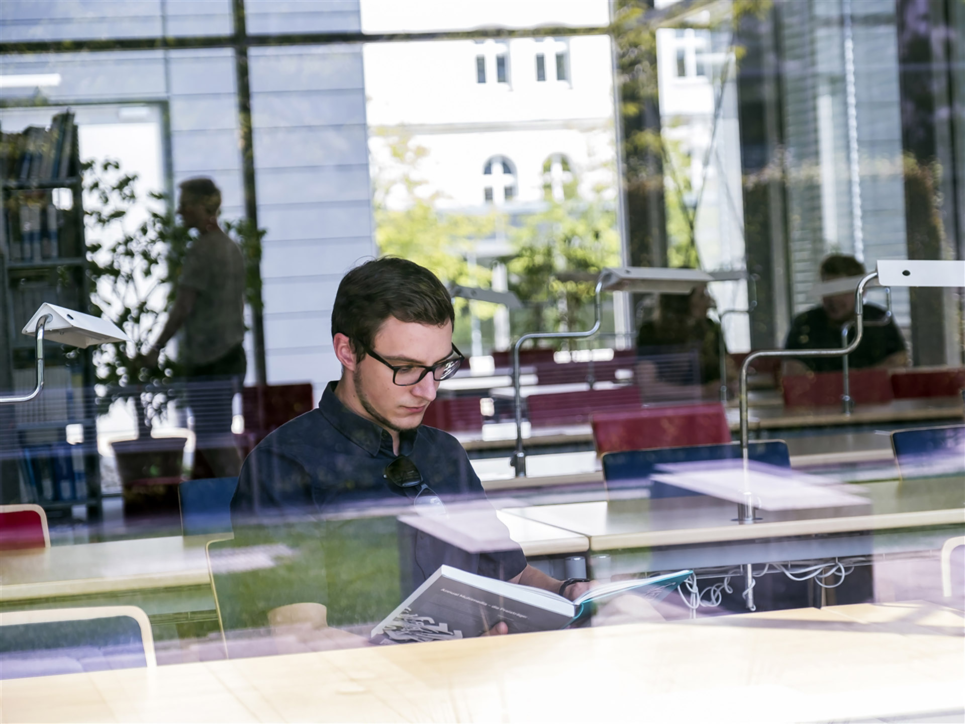 Raphael Gruber sitzt zum studieren in der Bibliothek der Universität