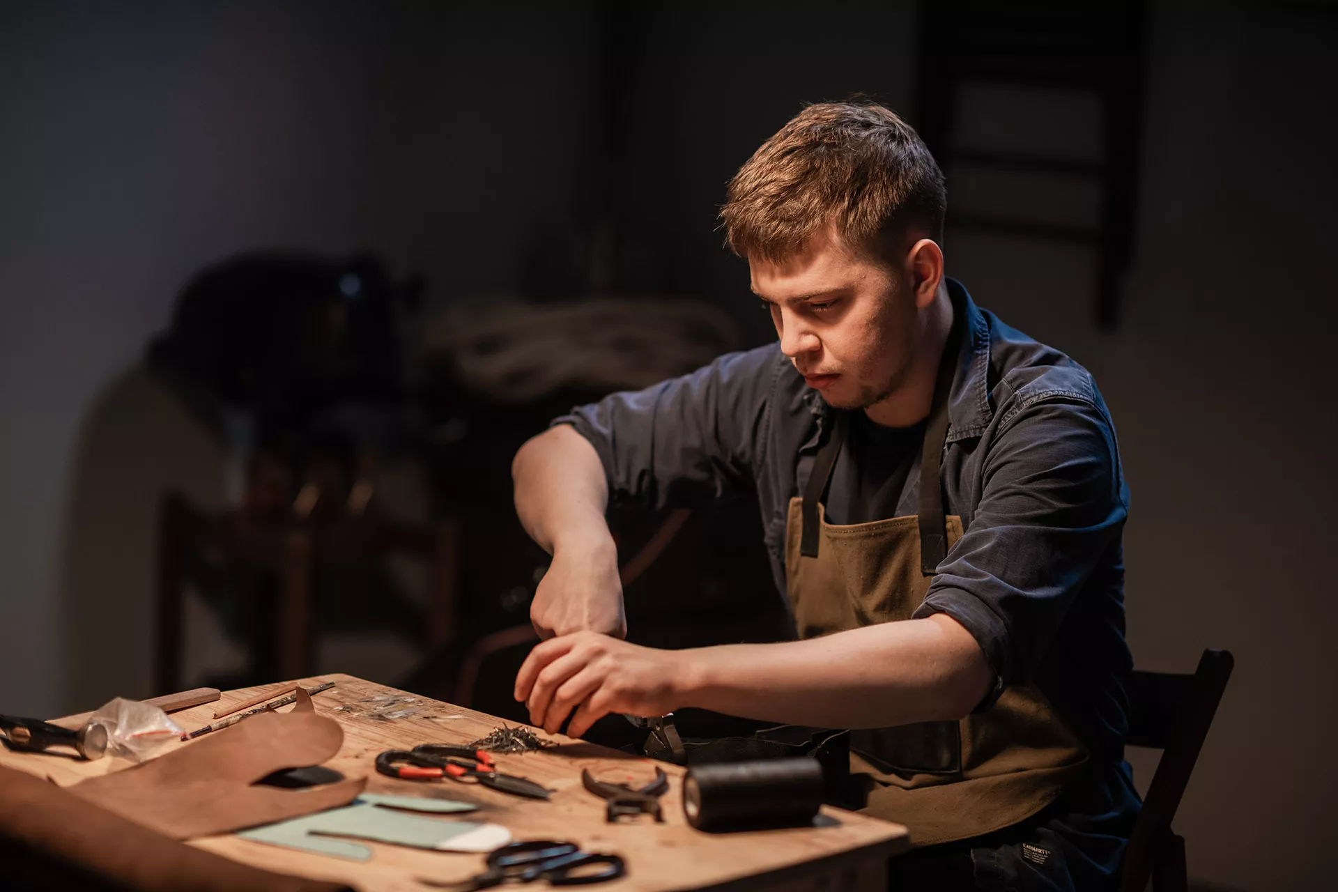 Ein Schuster fertigt einen Lederschuh in einer Werkstatt.