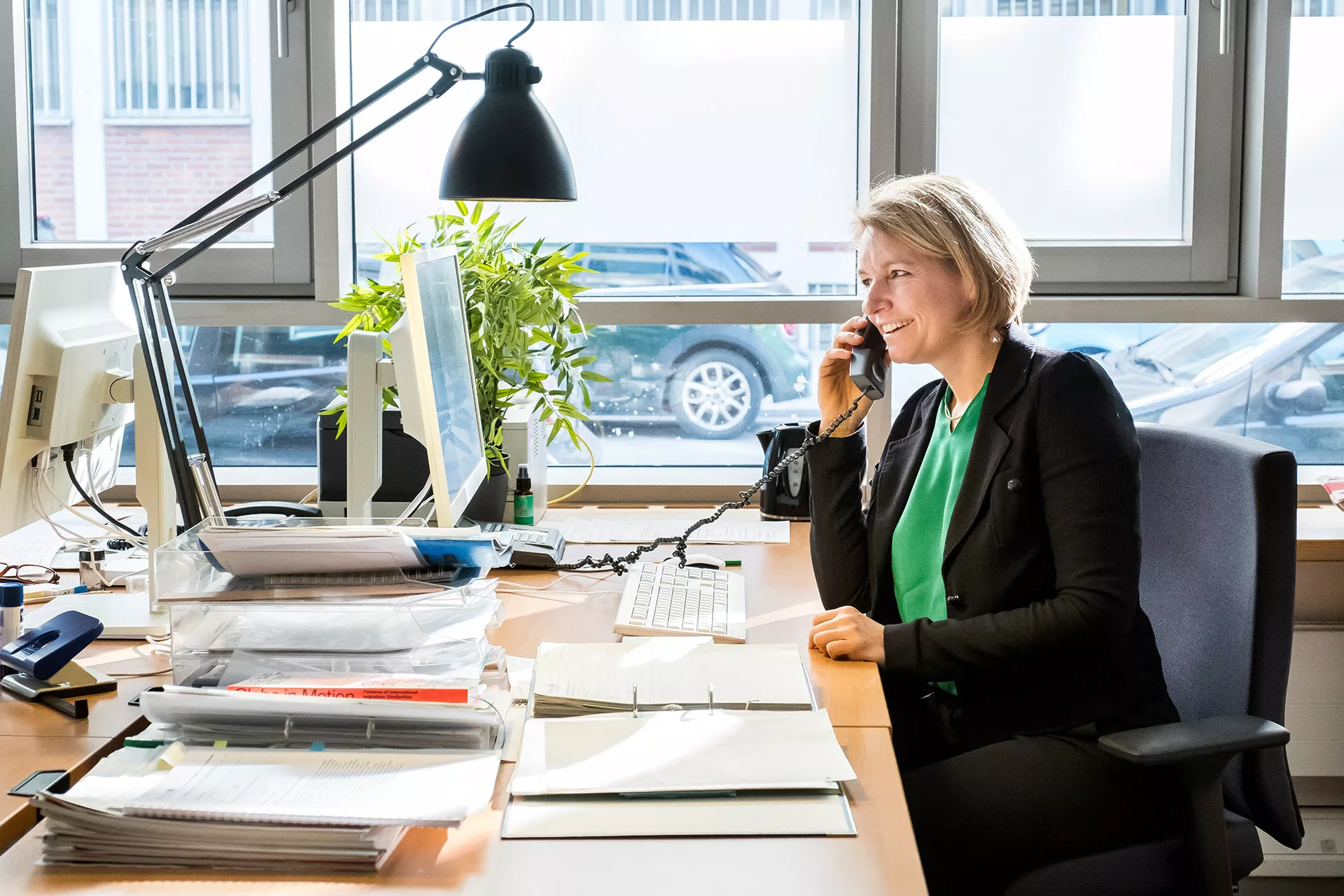 Frau Müller am Telefon an ihrem Schreibtisch