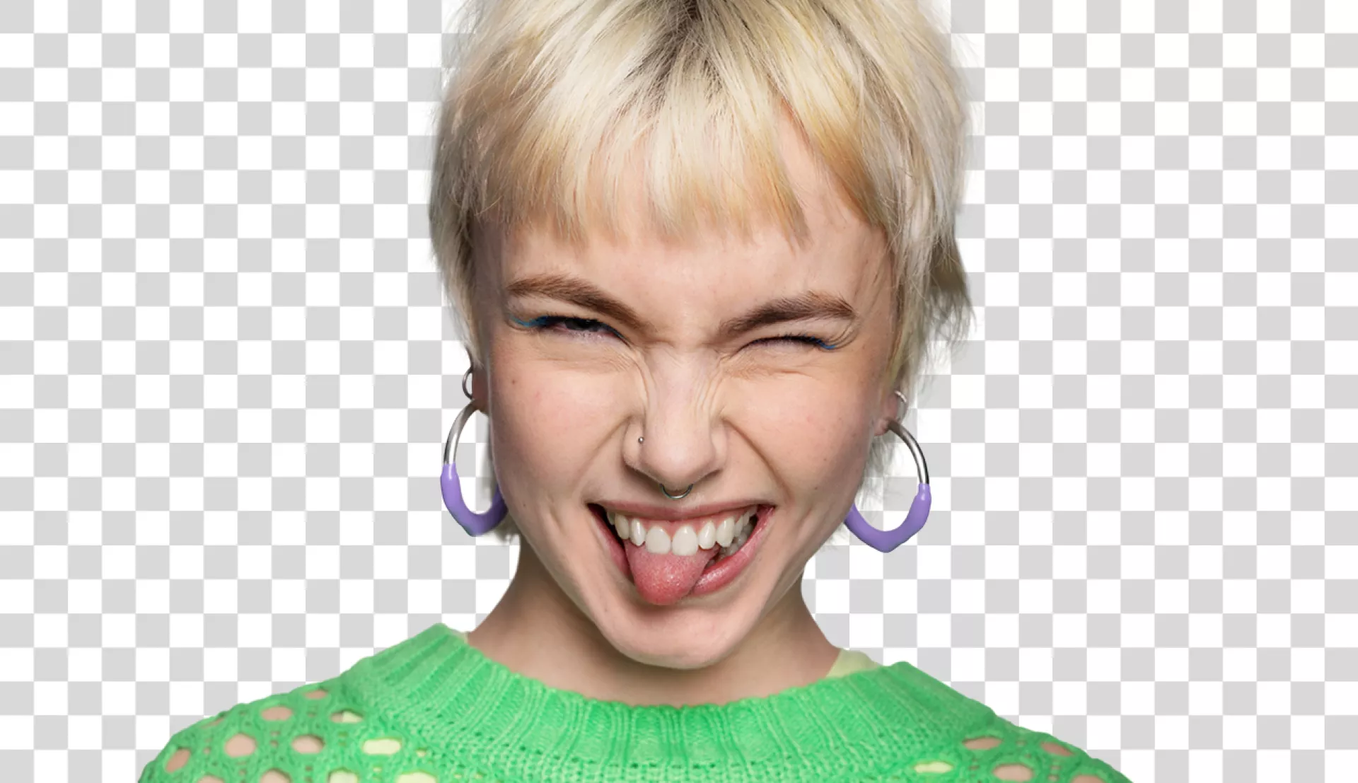 Junge Frau im grünen Pullover streckt die Zunge raus