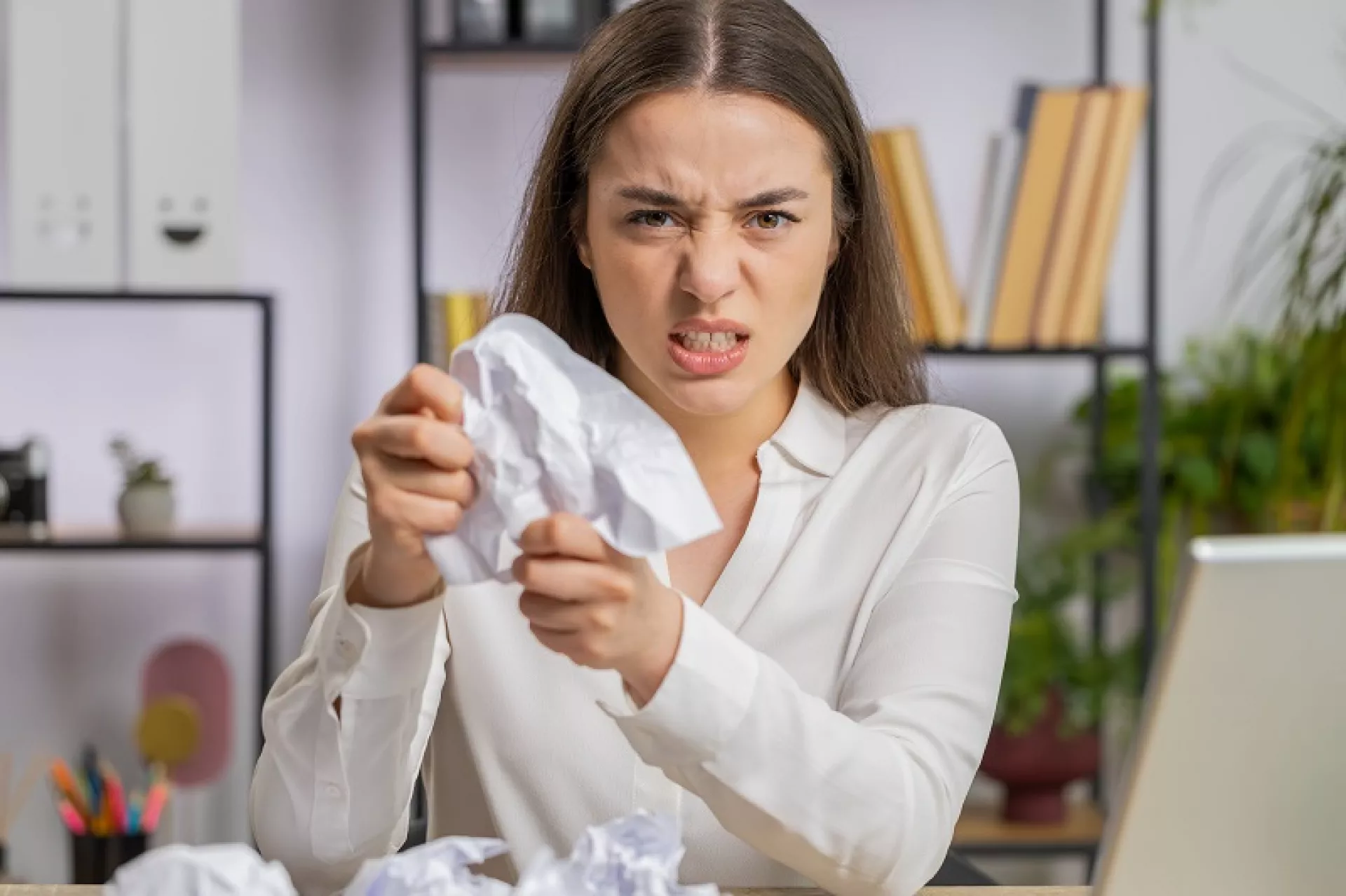 Eine Beschäftigte zerreißt vor Wut ein Stück Papier