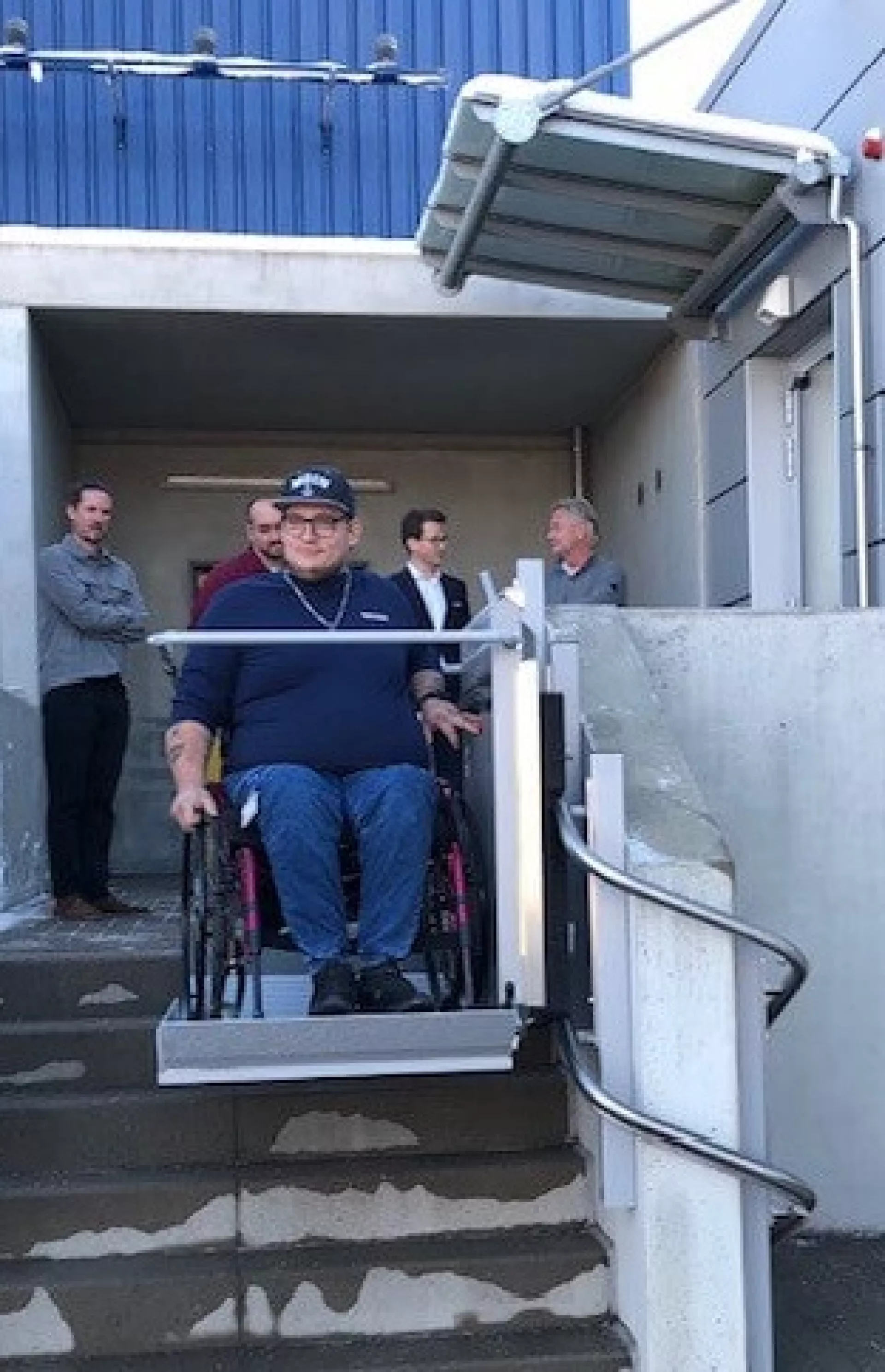 Dariean Bahr mit Rollstuhl am Außenlift.