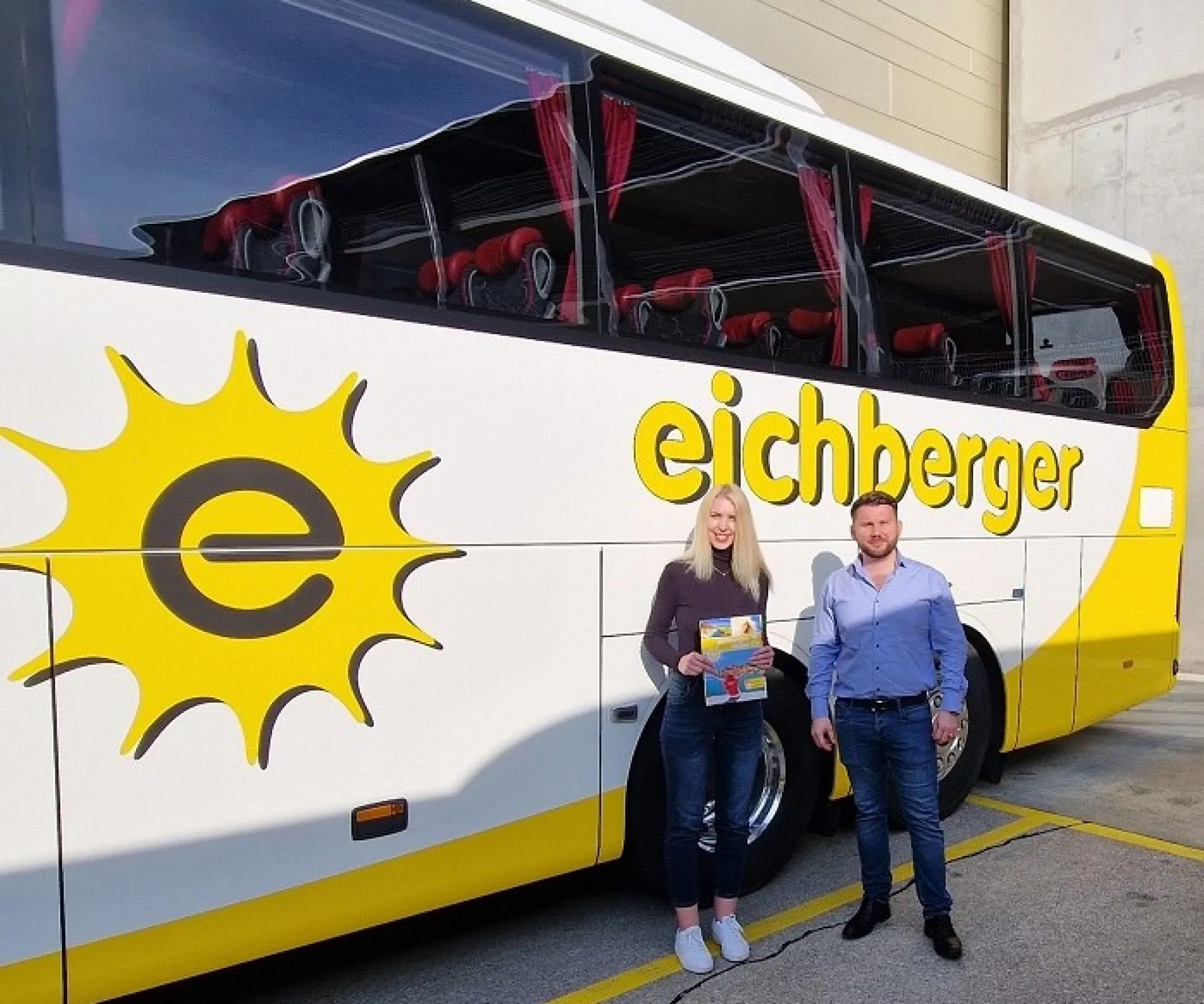 Viktoriia und Eugen Weigand von Eichberger Reisen stehen vor einem Reisebus