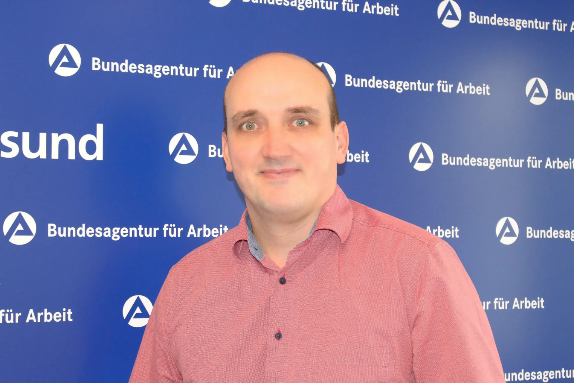 Mann mit rotem Hemd und Halbglatze