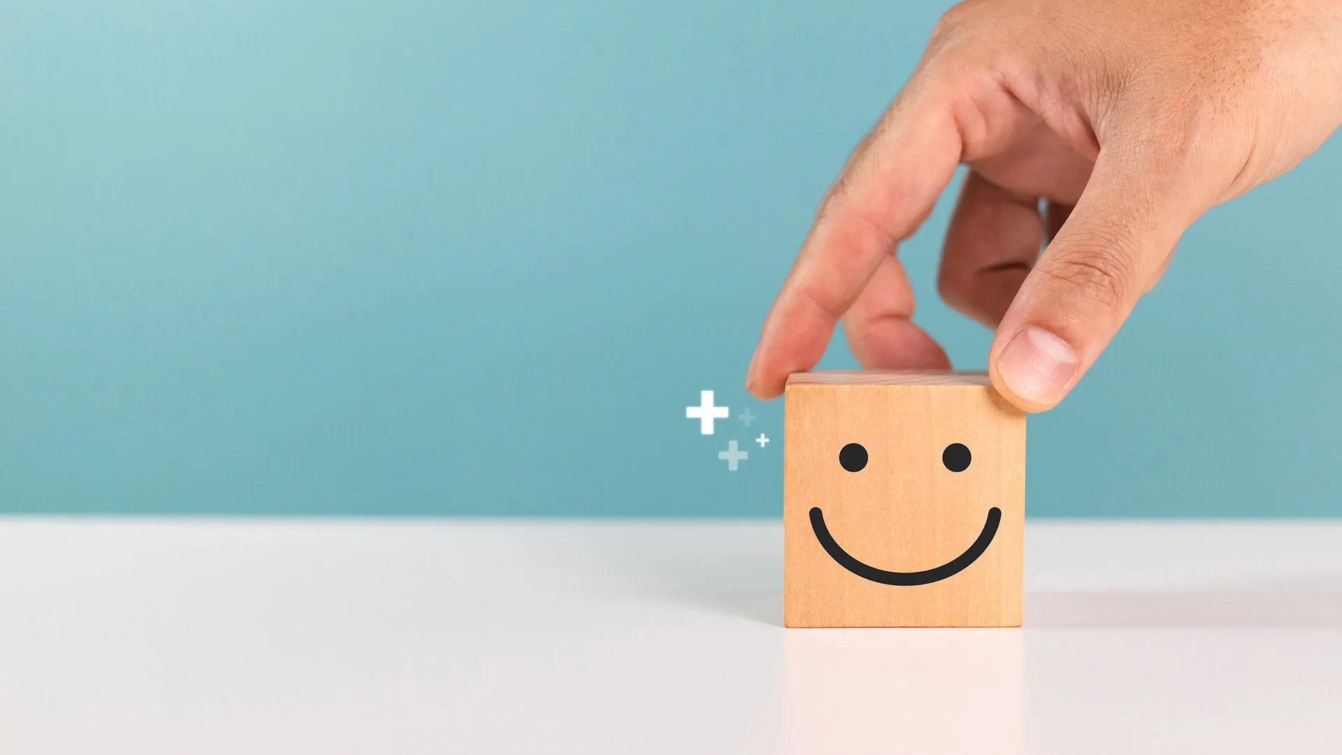 Konzept der Kundenzufriedenheit, Servicebewertung und positiven Rückmeldung. Ein Mann wählt einen Holzwürfel mit einem Smiley