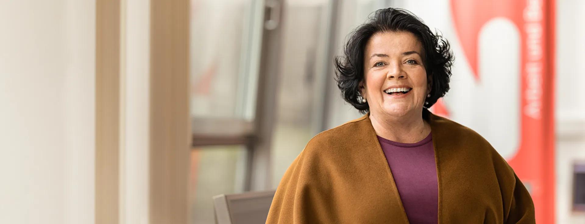 Marion, Frau mit dunklen kinnlangen Haaren, lächelt